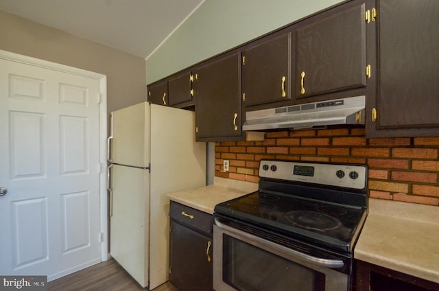 kitchen featuring decorative backsplash, freestanding refrigerator, stainless steel electric stove, light countertops, and under cabinet range hood