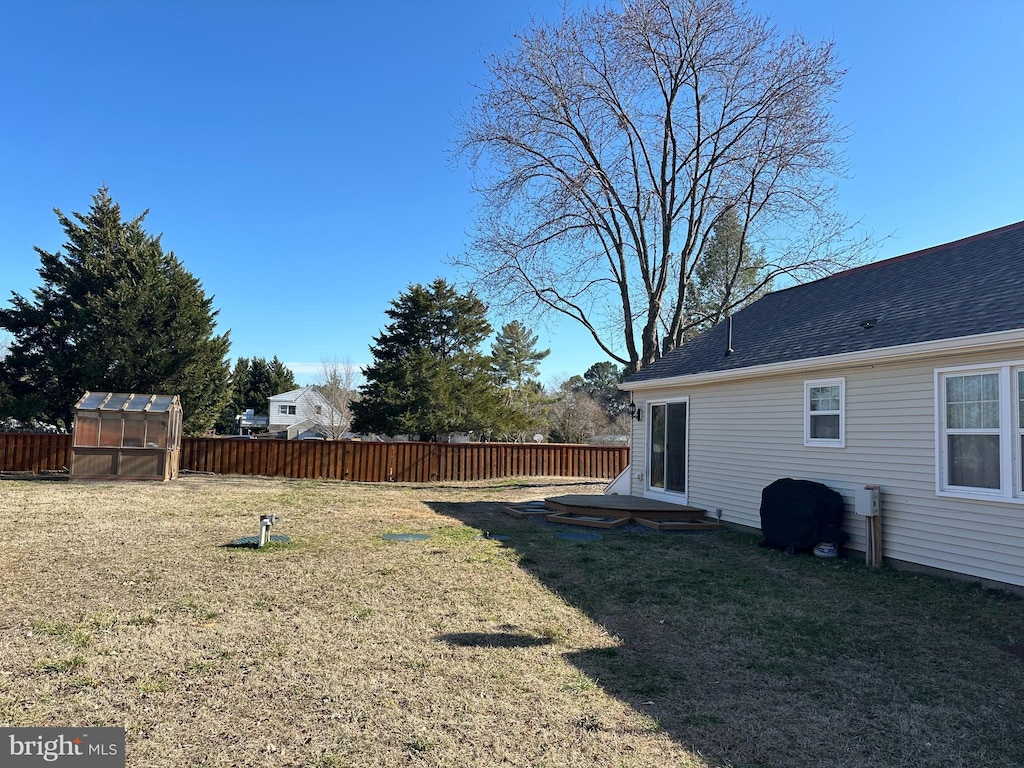 view of yard with an outbuilding, an exterior structure, and fence