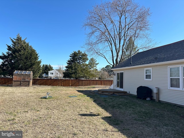 view of yard with an outbuilding, an exterior structure, and fence