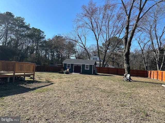 view of yard with an outdoor structure, a fenced backyard, and a wooden deck