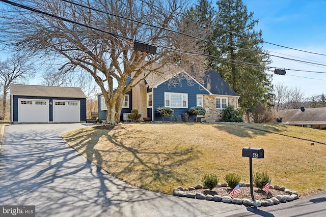 view of front of property with a garage, driveway, an outdoor structure, and a front lawn