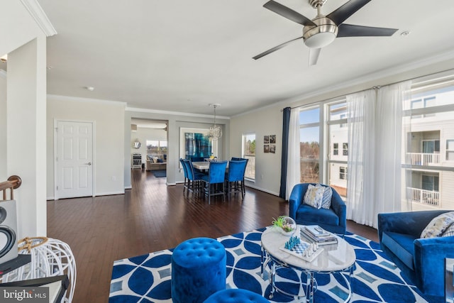 living area with ornamental molding, baseboards, ceiling fan, and hardwood / wood-style floors