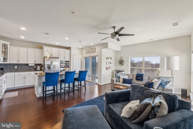 living area with baseboards, visible vents, dark wood finished floors, recessed lighting, and ceiling fan