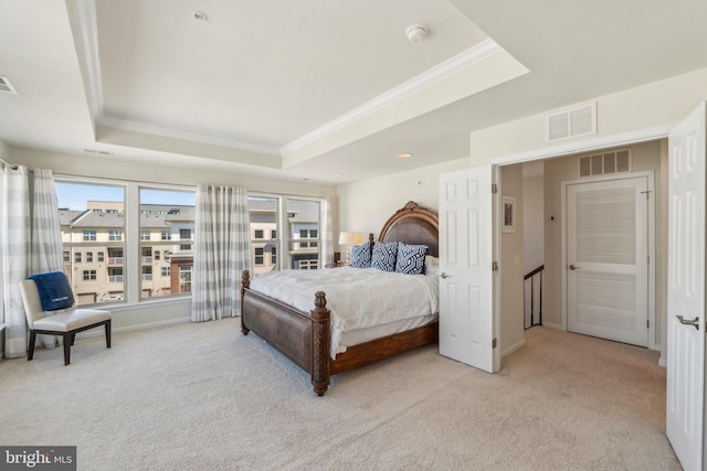 carpeted bedroom featuring visible vents and a tray ceiling