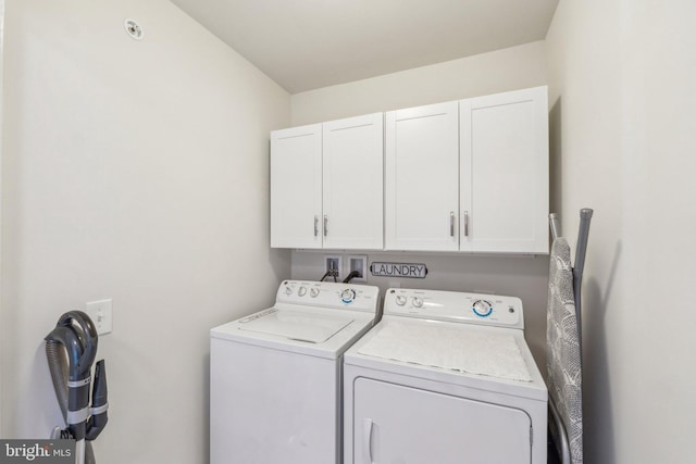 washroom featuring washing machine and dryer and cabinet space