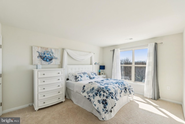 bedroom with light colored carpet and baseboards