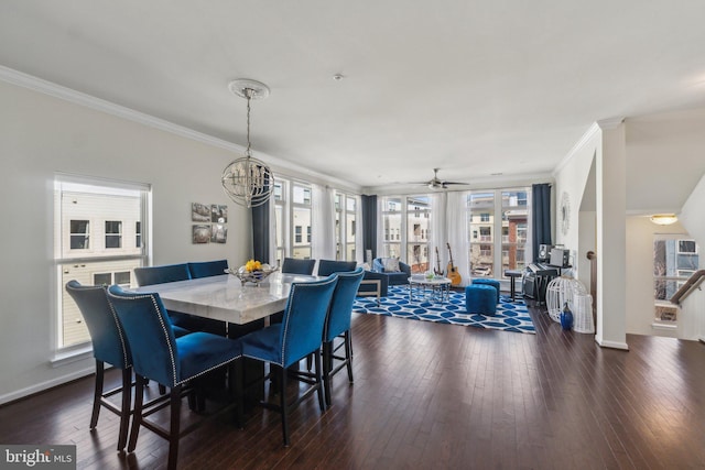 dining space featuring ceiling fan with notable chandelier, dark wood-type flooring, baseboards, and ornamental molding