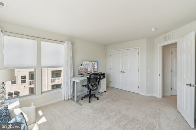 carpeted office with visible vents and baseboards