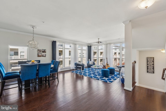 dining space featuring ceiling fan with notable chandelier, crown molding, baseboards, and hardwood / wood-style floors