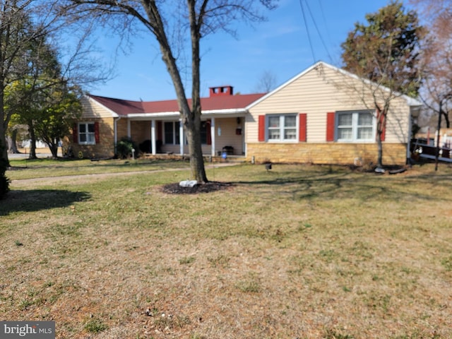 single story home featuring a chimney and a front yard