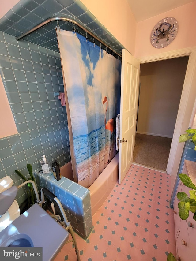 full bathroom featuring tile patterned floors, shower / bath combo with shower curtain, and tile walls