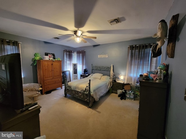 carpeted bedroom with visible vents and ceiling fan