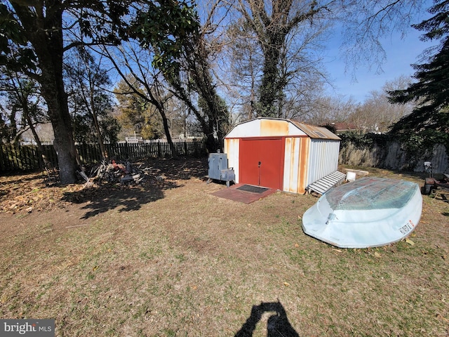 view of yard with an outbuilding, a storage shed, and a fenced backyard