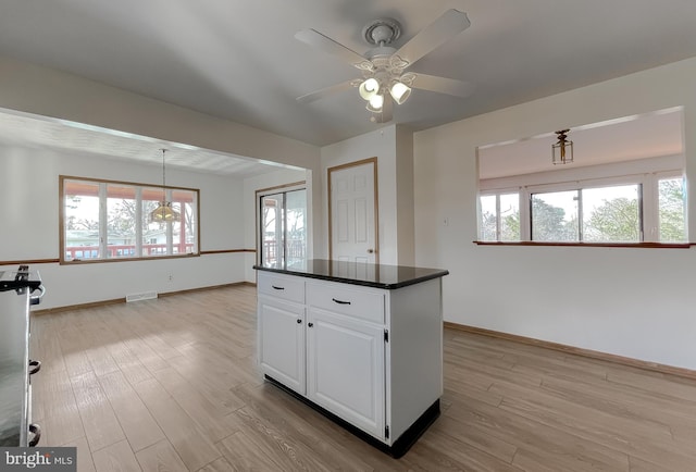 kitchen featuring dark countertops, light wood finished floors, visible vents, and a wealth of natural light