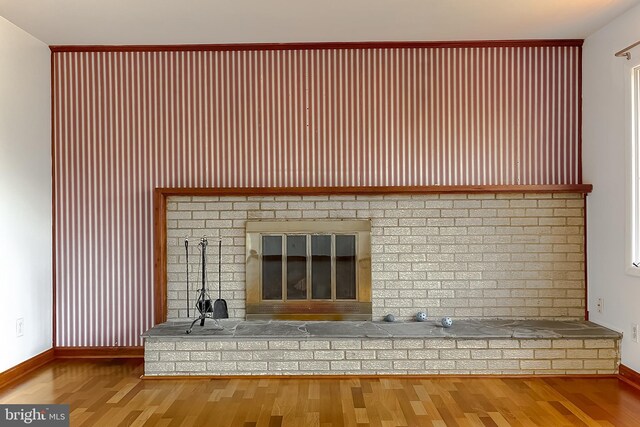 interior details featuring a fireplace, baseboards, and wood finished floors