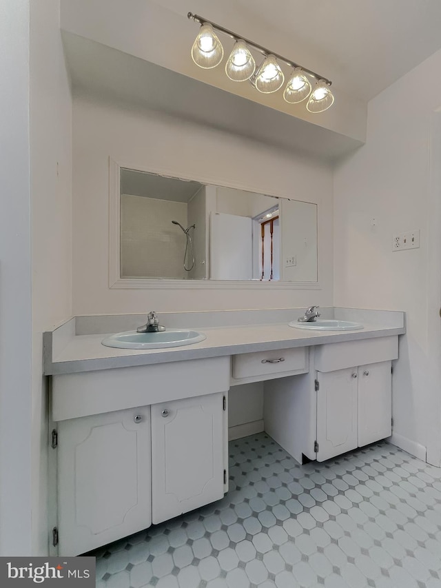 full bath with a sink, double vanity, and tile patterned floors