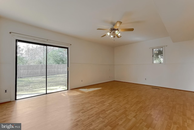 unfurnished room with baseboards, light wood-type flooring, and a ceiling fan