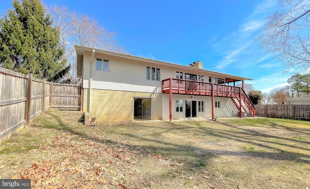 rear view of property featuring brick siding, stairway, a chimney, a yard, and a fenced backyard