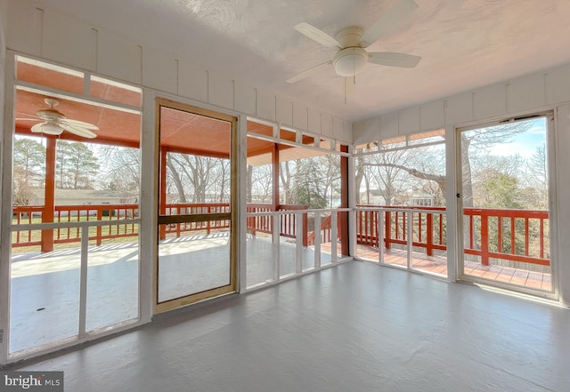 unfurnished sunroom with ceiling fan