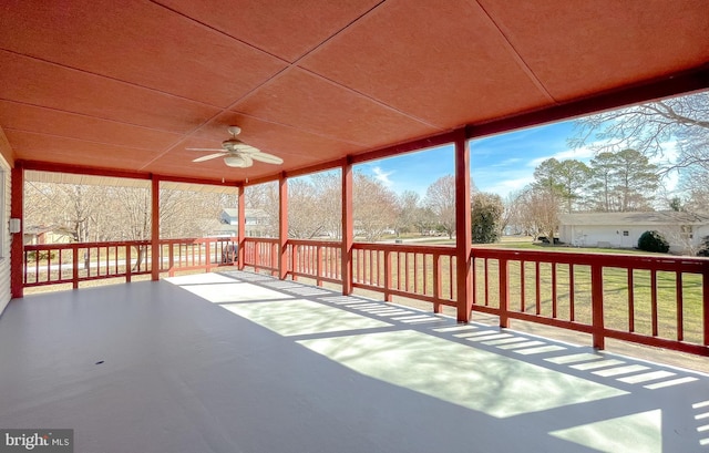 unfurnished sunroom featuring ceiling fan