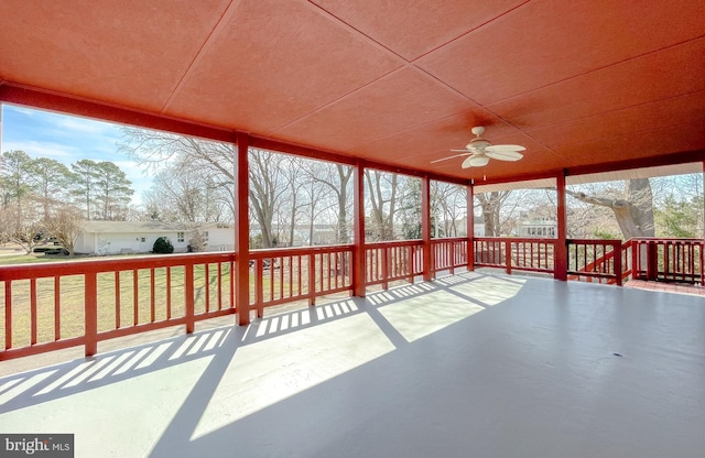 unfurnished sunroom with ceiling fan