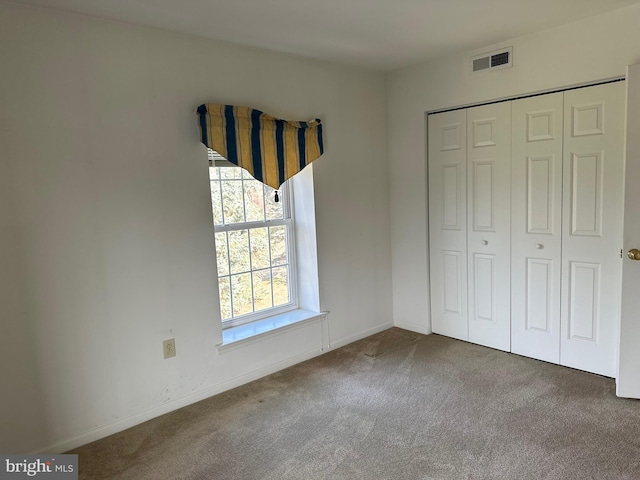 unfurnished bedroom featuring a closet, baseboards, visible vents, and carpet floors