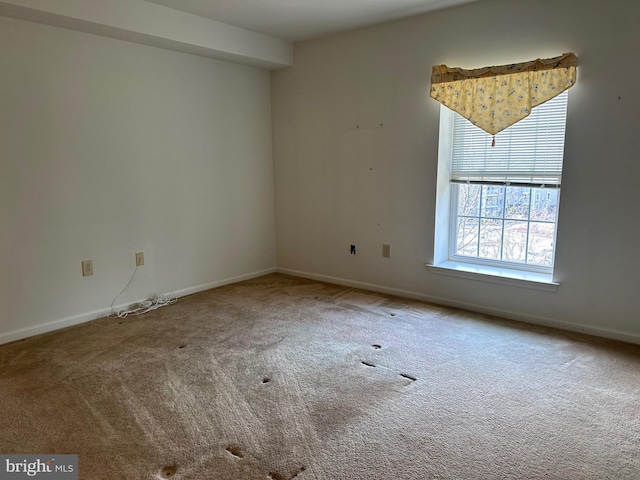 unfurnished room featuring carpet flooring and baseboards