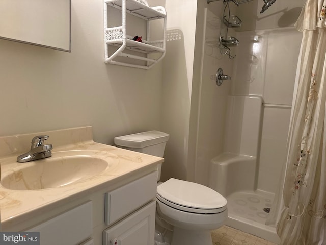 bathroom featuring vanity, toilet, and a stall shower