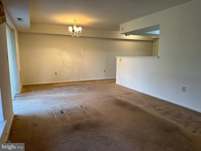 empty room featuring baseboards, carpet floors, visible vents, and a chandelier