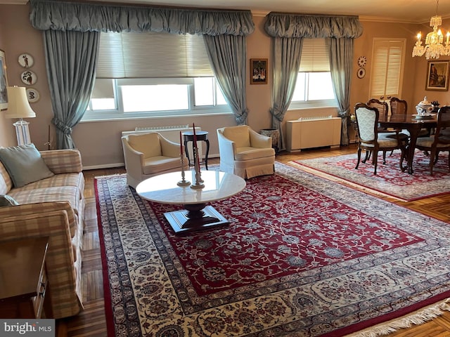 living area featuring an inviting chandelier, radiator, and crown molding