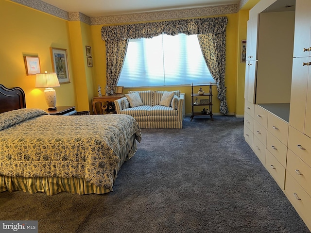 bedroom featuring dark carpet and baseboards