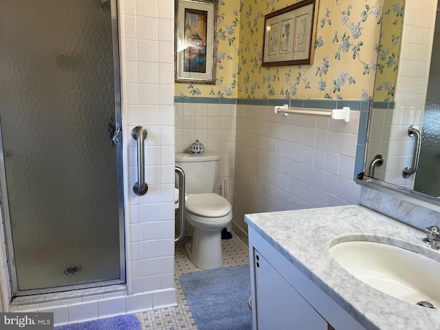 bathroom with a wainscoted wall, wallpapered walls, a stall shower, tile walls, and tile patterned floors