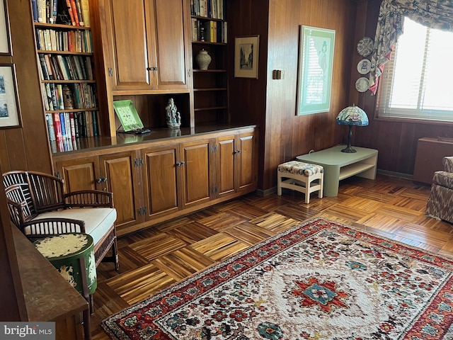 living area featuring baseboards and wood walls