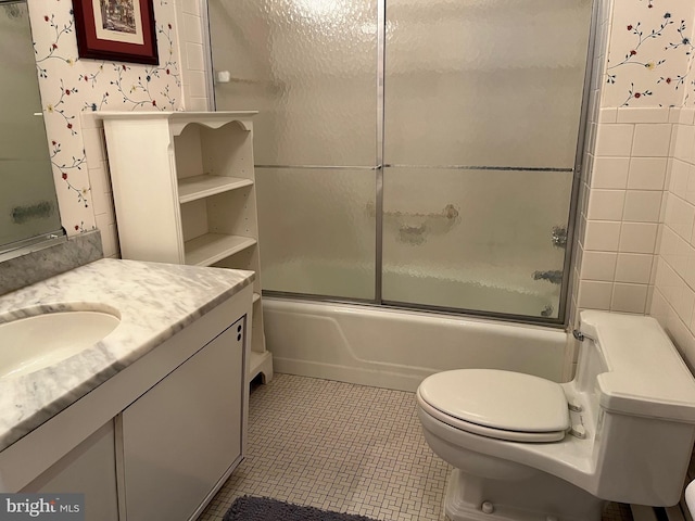 bathroom with vanity, tile patterned floors, toilet, and shower / bath combination with glass door