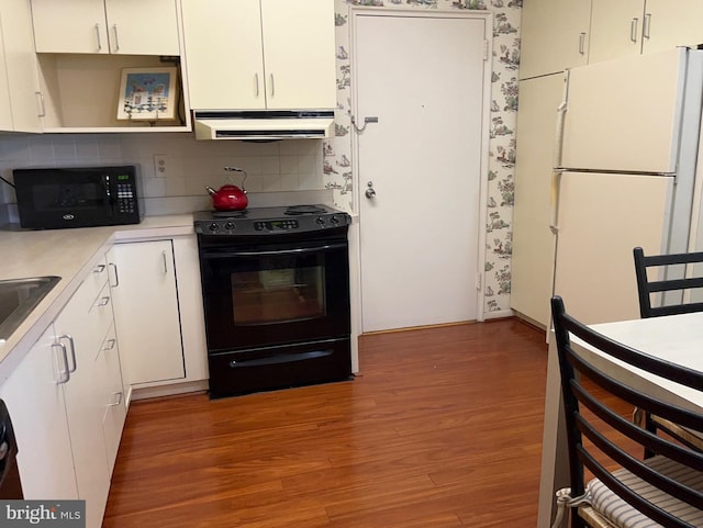 kitchen with extractor fan, black appliances, light wood-style flooring, and light countertops