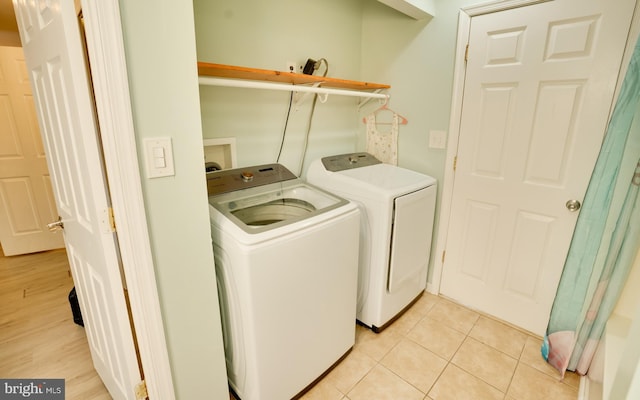 laundry room featuring laundry area, light tile patterned flooring, and washer and clothes dryer