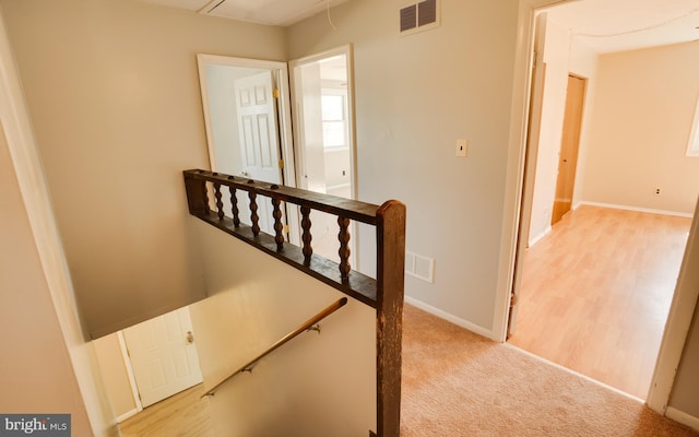 staircase with attic access, carpet flooring, baseboards, and visible vents