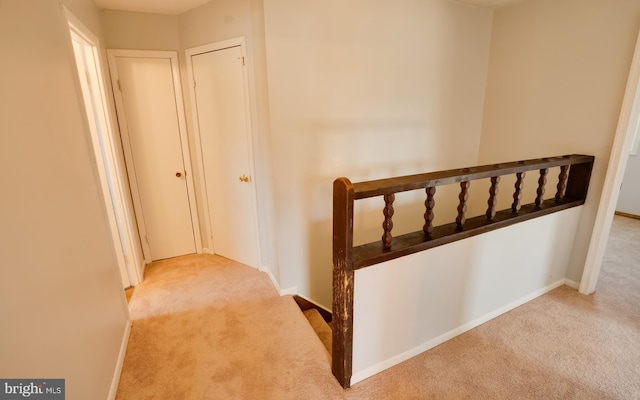 corridor featuring an upstairs landing, carpet, and baseboards