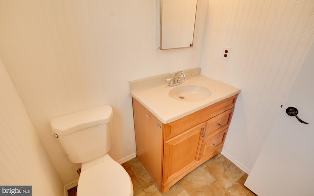 bathroom with vanity, toilet, and baseboards