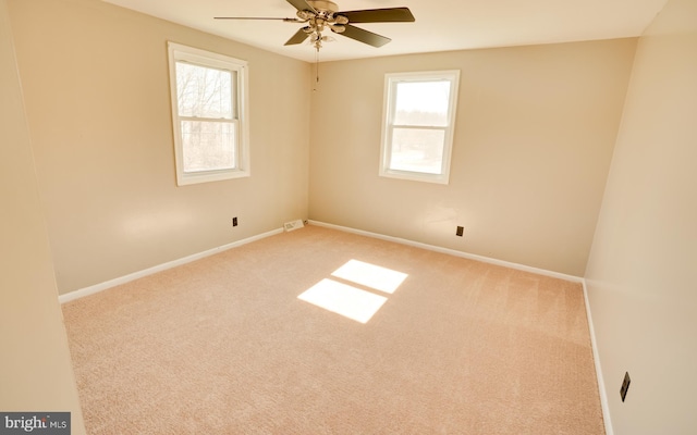 carpeted empty room featuring baseboards, a healthy amount of sunlight, and ceiling fan