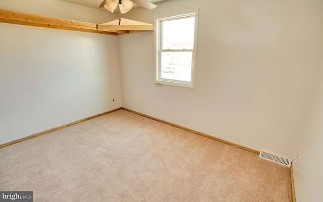 spare room featuring visible vents, light carpet, and baseboards