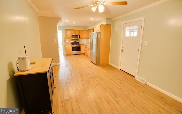 kitchen with light wood-type flooring, visible vents, ornamental molding, backsplash, and stainless steel appliances