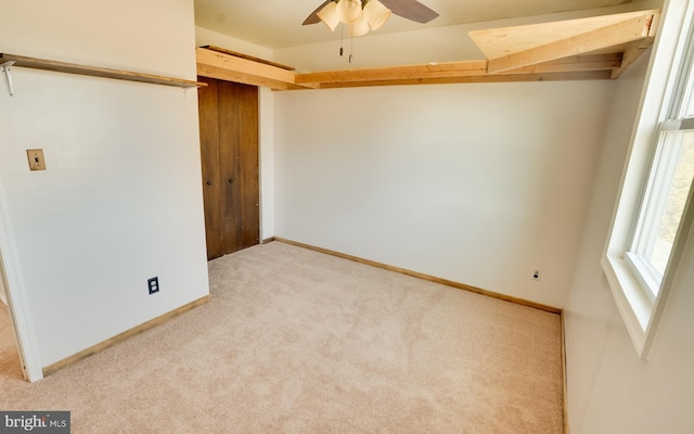 unfurnished bedroom with a ceiling fan, light colored carpet, baseboards, and a closet