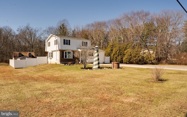 colonial house with a front lawn and fence