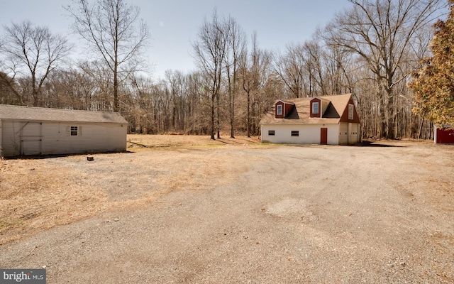 view of yard featuring an outbuilding and dirt driveway