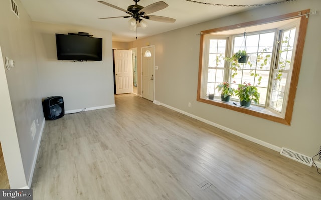 unfurnished living room featuring visible vents, a ceiling fan, baseboards, and wood finished floors