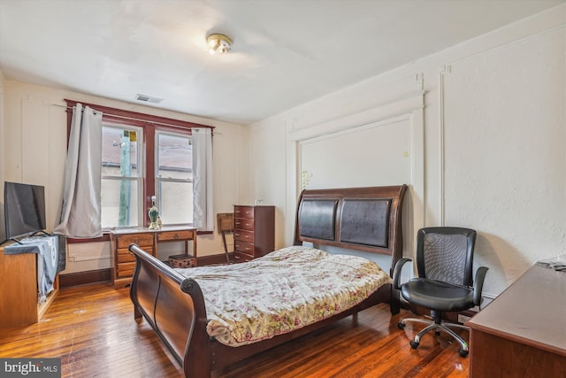 bedroom featuring visible vents and dark wood-style flooring