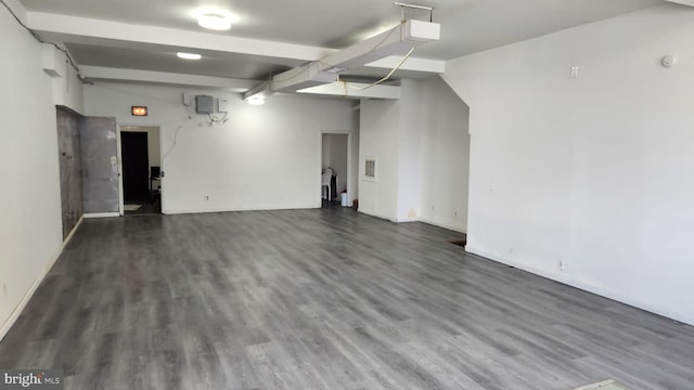 basement with a garage, wood finished floors, and baseboards