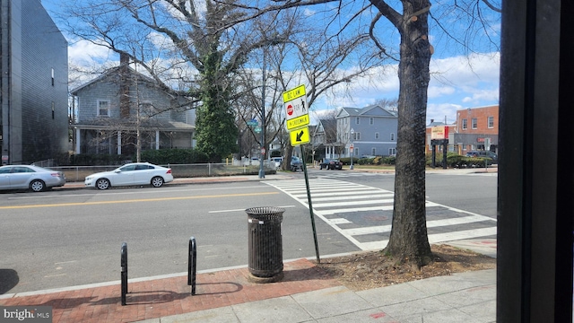 view of road with sidewalks, curbs, and traffic signs