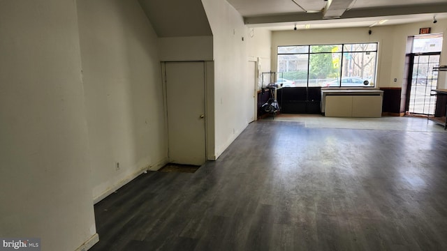 unfurnished room featuring a healthy amount of sunlight, baseboards, and wood finished floors